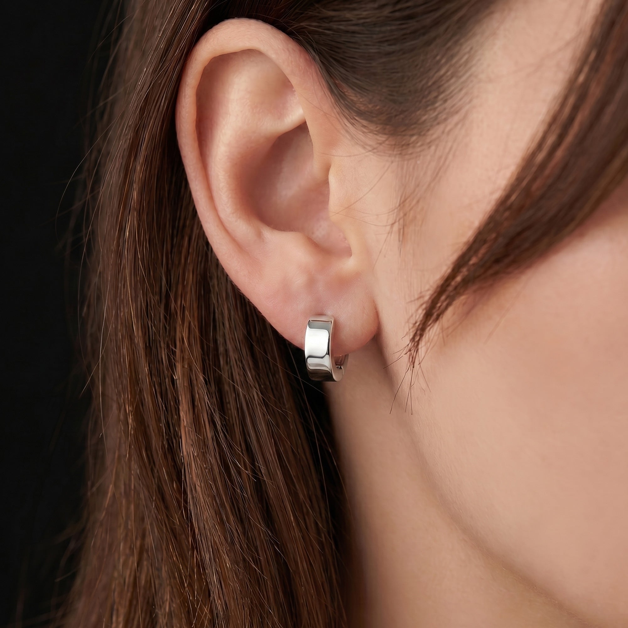 Woman wearing Engelsrufer mini huggie hoop sterling silver earrings.