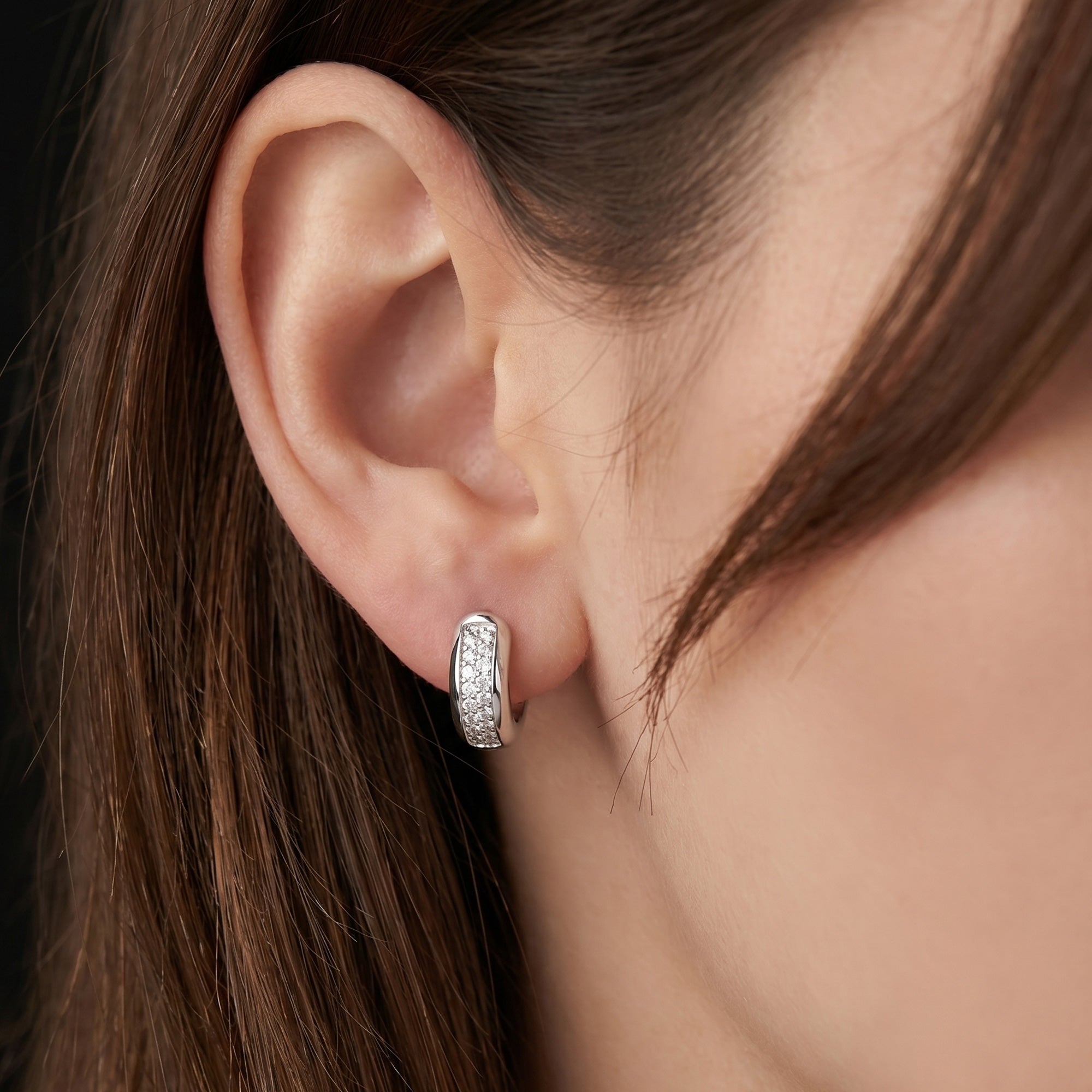 Woman wearing Engelsrufer mini rounded huggie hoop CZ sterling silver earrings.