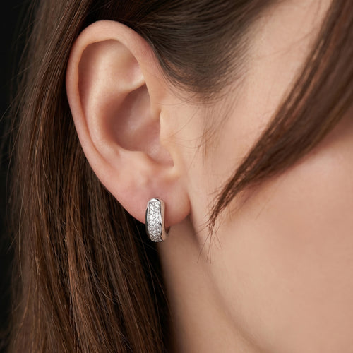 Woman wearing Engelsrufer mini rounded huggie hoop CZ sterling silver earrings.