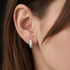 Woman wearing Engelsrufer mini rounded huggie hoop CZ sterling silver earrings.