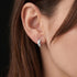 Woman wearing Engelsrufer mini rounded huggie rounded hoop sterling silver earrings.