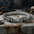 Hydra dragon sterling silver bracelet on broken concrete in an industrial grunge setting.