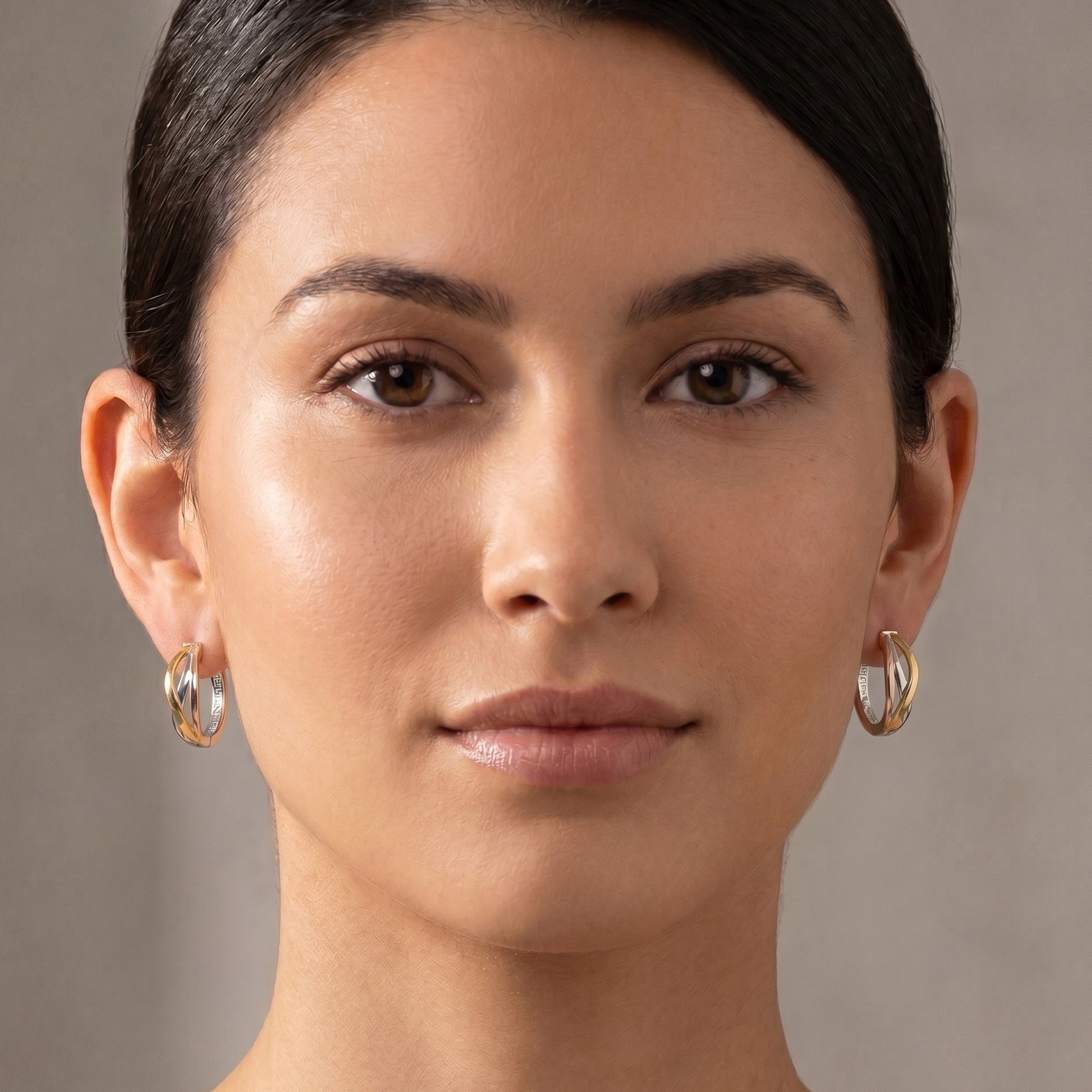 Woman wearing a pair of Engelsrufer infinity paradise tricolour hoop earrings.