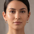 Woman wearing a pair of Engelsrufer infinity paradise tricolour hoop earrings.