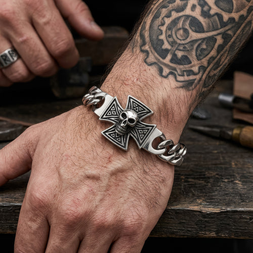 Man with a tattooed arm wearing an Iron Cross skull Cuban link stainless steel bracelet.
