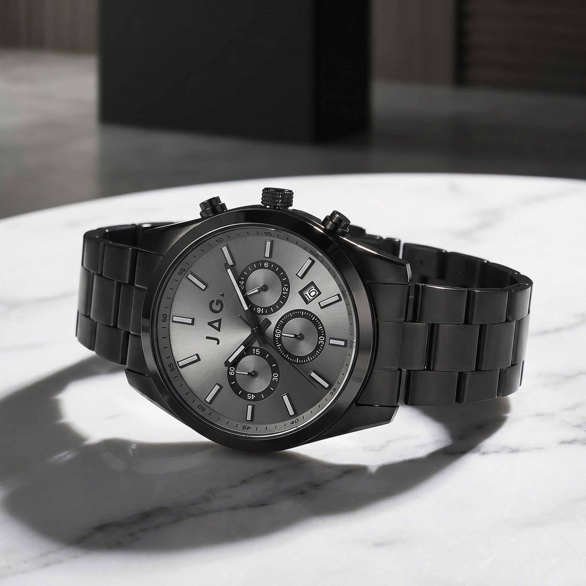 JAG Acton men's all black watch site on a white marble tabletop.