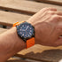 Man wearing a JAG Beachport black dial orange sport chronograph men's watch on his wrist.