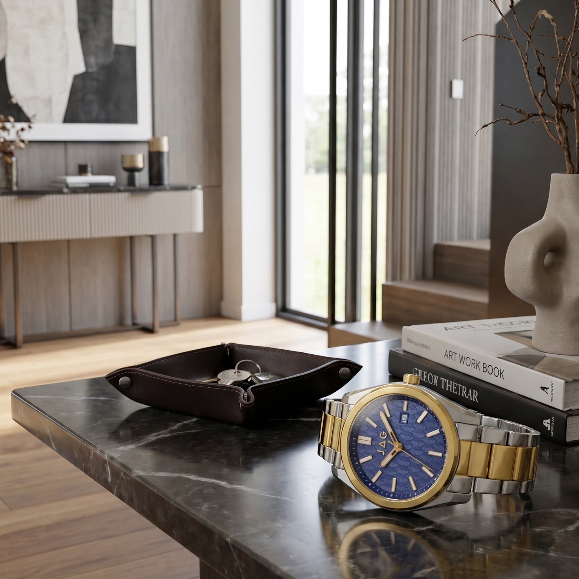 A JAG Beaufort blue dial two-tone men's watch laying on a marble table inside a modern home.