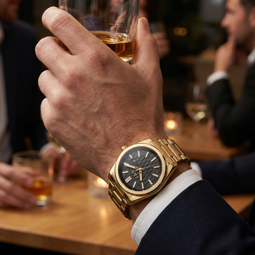 Man wearing a JAG Beaufort black dial gold men's watch at a drinks gathering.