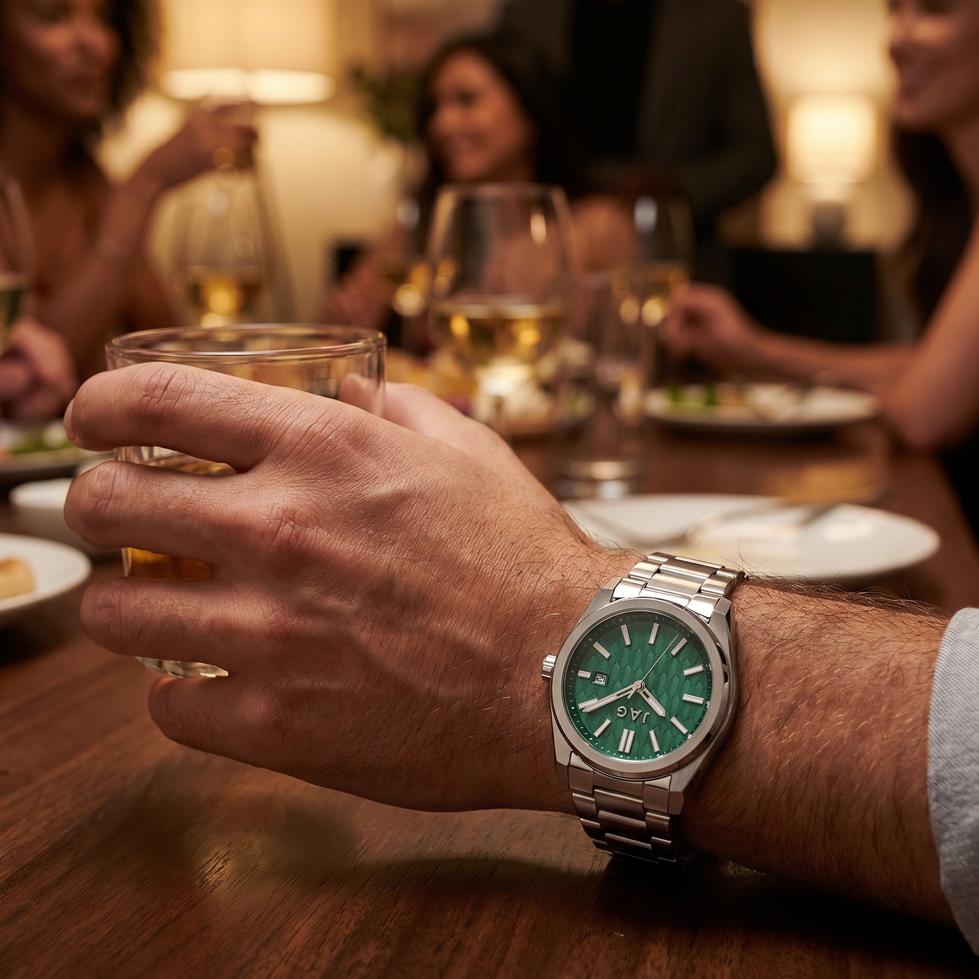 Man wearing a JAG Beaufort green dial silver men's watch on his wrist at a social gathering.
