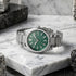 JAG Beaufort green dial silver men's watch laying on a grey marble surface.