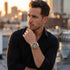 Man in a black shirt wearing a JAG Boss Black dial men's gold chronograph watch.