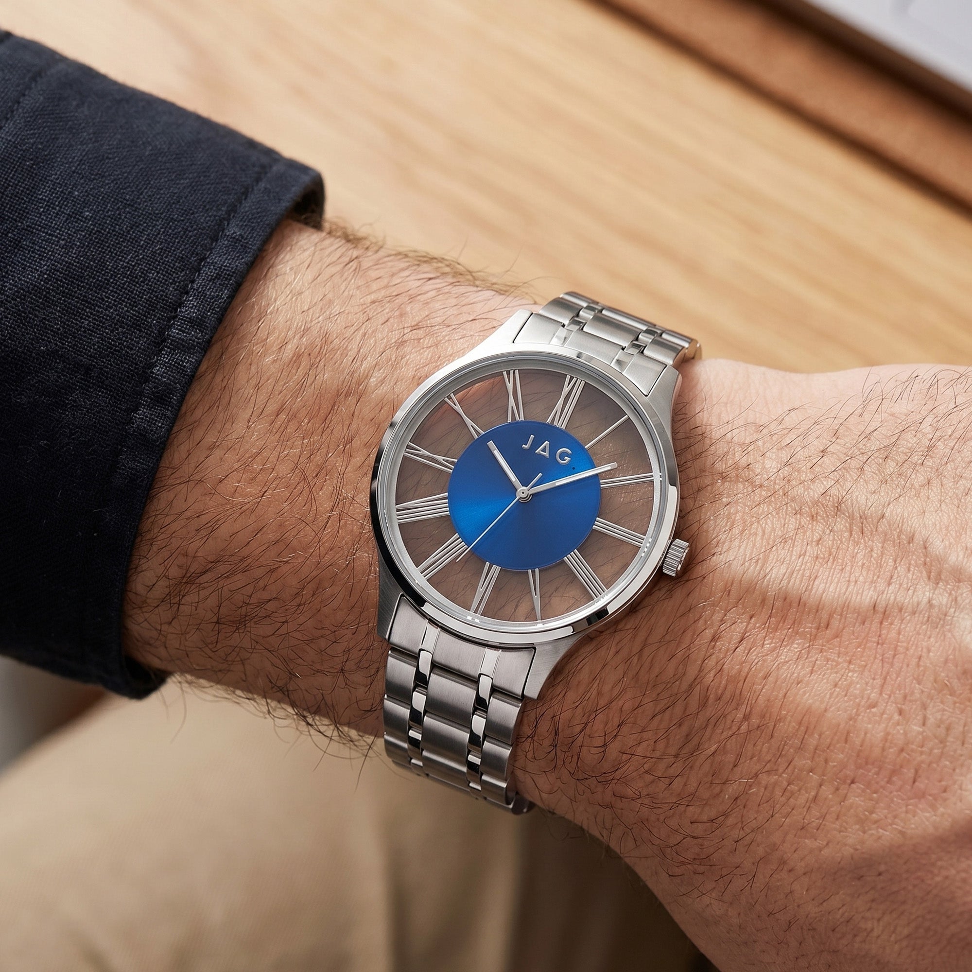 Close-up of man wearing a JAG Gerroa silver blue dial transparent watch on his wrist.