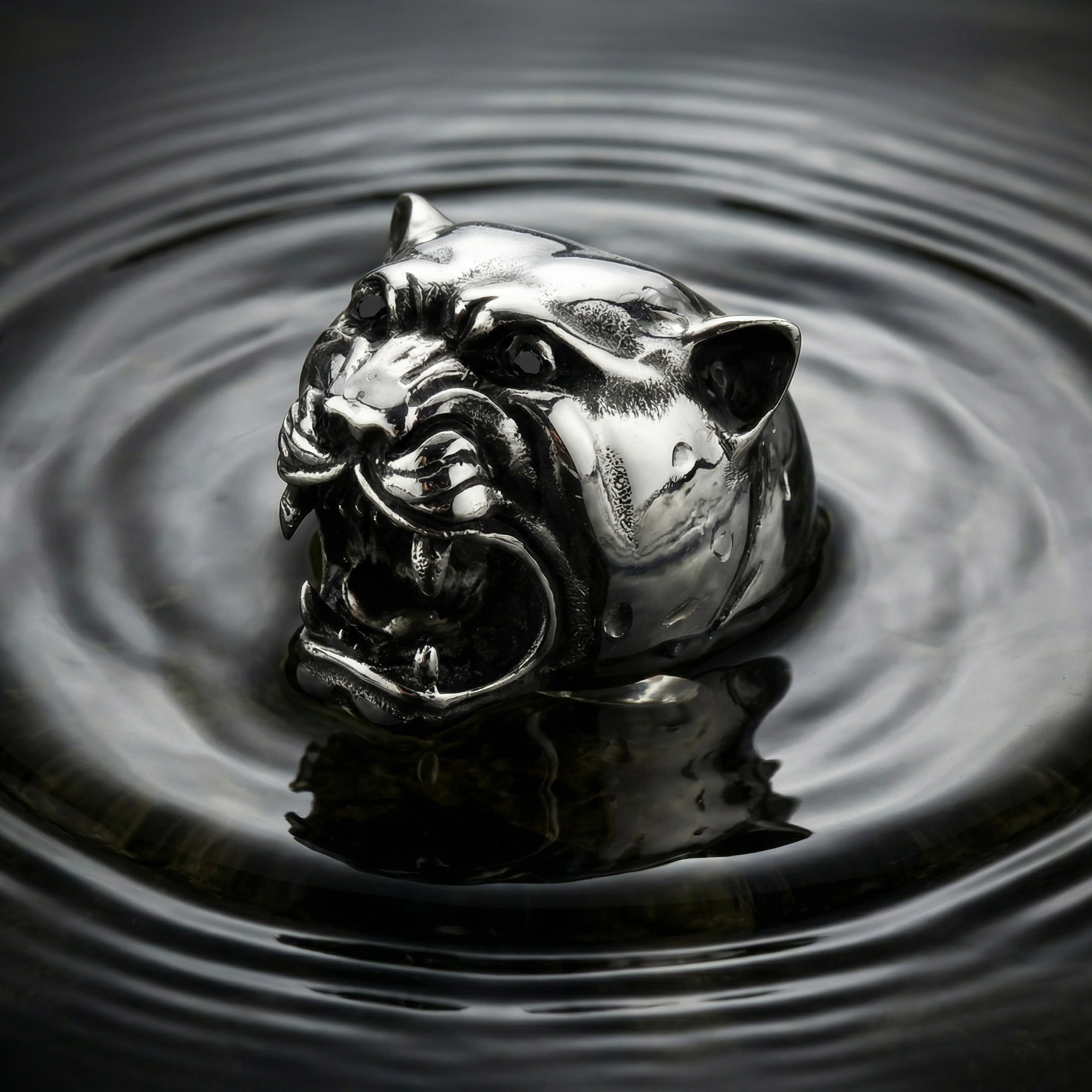 Snarling jaguar head stainless steel men's ring emerging from the surface of a rippling water.