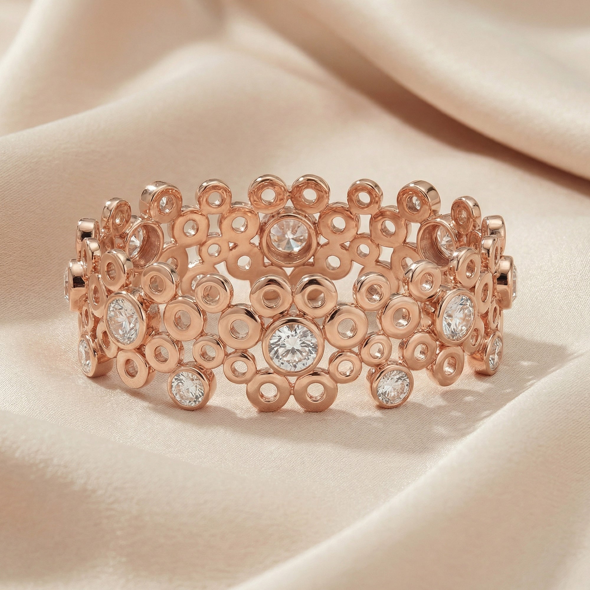 Kagi champagne bubbles rose gold cuff bracelet on soft fabric.
