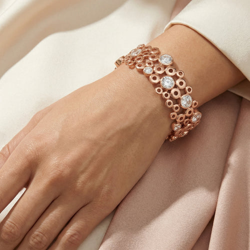 Woman wearing Kagi champagne bubbles rose gold cuff bracelet.