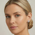 Woman with head tilted to the left wearing Kagi snowflake stainless steel stud earrings.