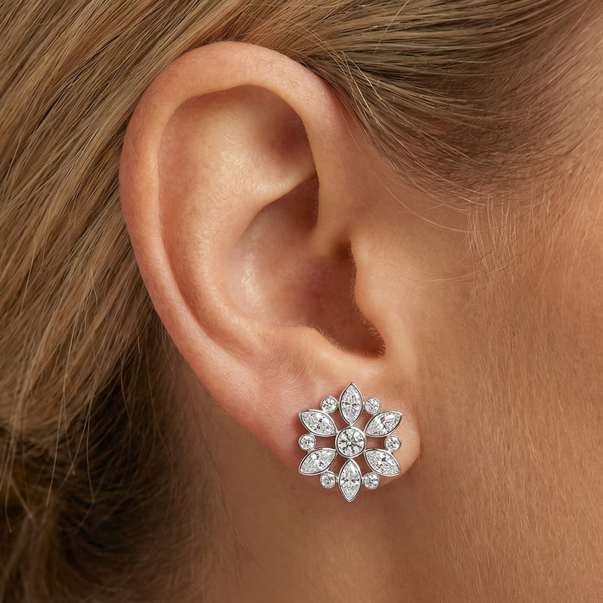 Close-up of woman wearing Kagi snowflake stainless steel stud earrings.