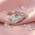 Irish Claddagh solitaire stainless steel ladies ring laying on a pink fabric surrounded by crystals.