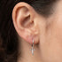 Woman wearing Engelsrufer little angel silver hoop earrings.