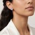 Close-up of woman wearing Engelsrufer lucky eye silver blue enamel circle earrings.