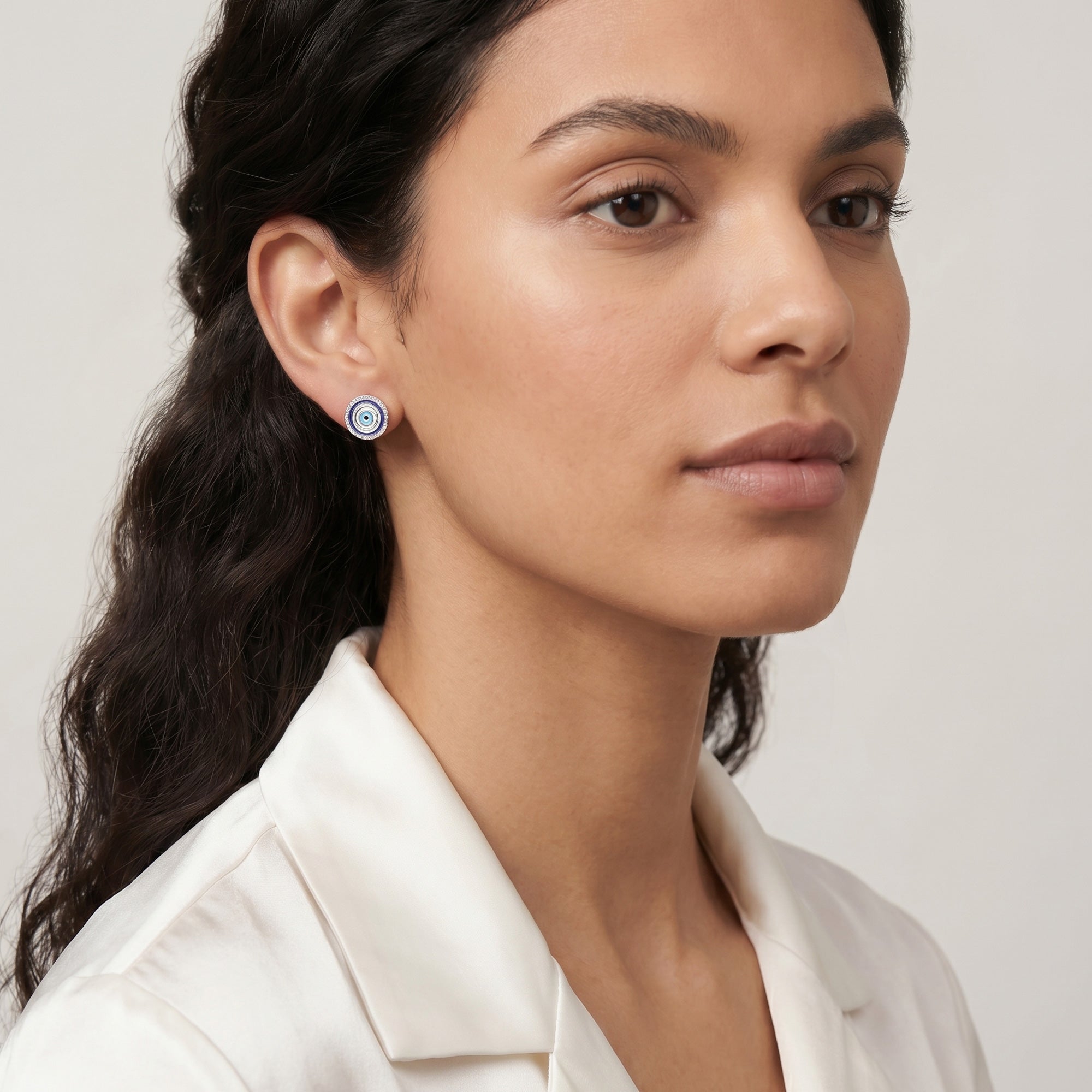 Woman looking to the right wearing Engelsrufer lucky eye silver blue enamel circle earrings.