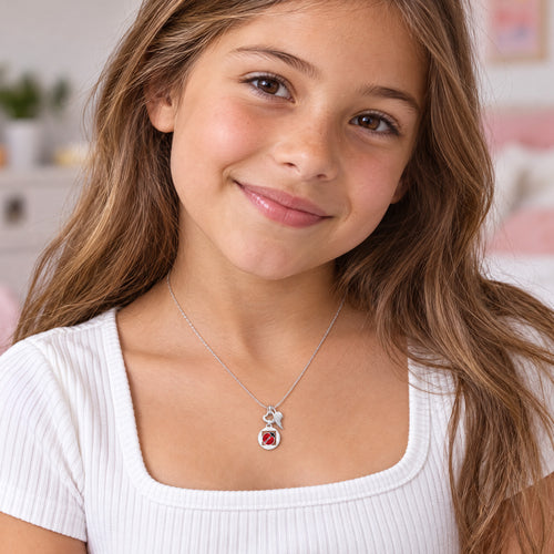 Young girl wearing Herzengel lucky ladybug heart wing silver children's necklace.