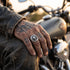 Man sitting on a motorcycle wearing a memento mori skull stainless steel signet ring.