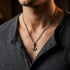 Man in an open-neck shirt wearing Anchor & Crew mini anchor sterling silver necklace.
