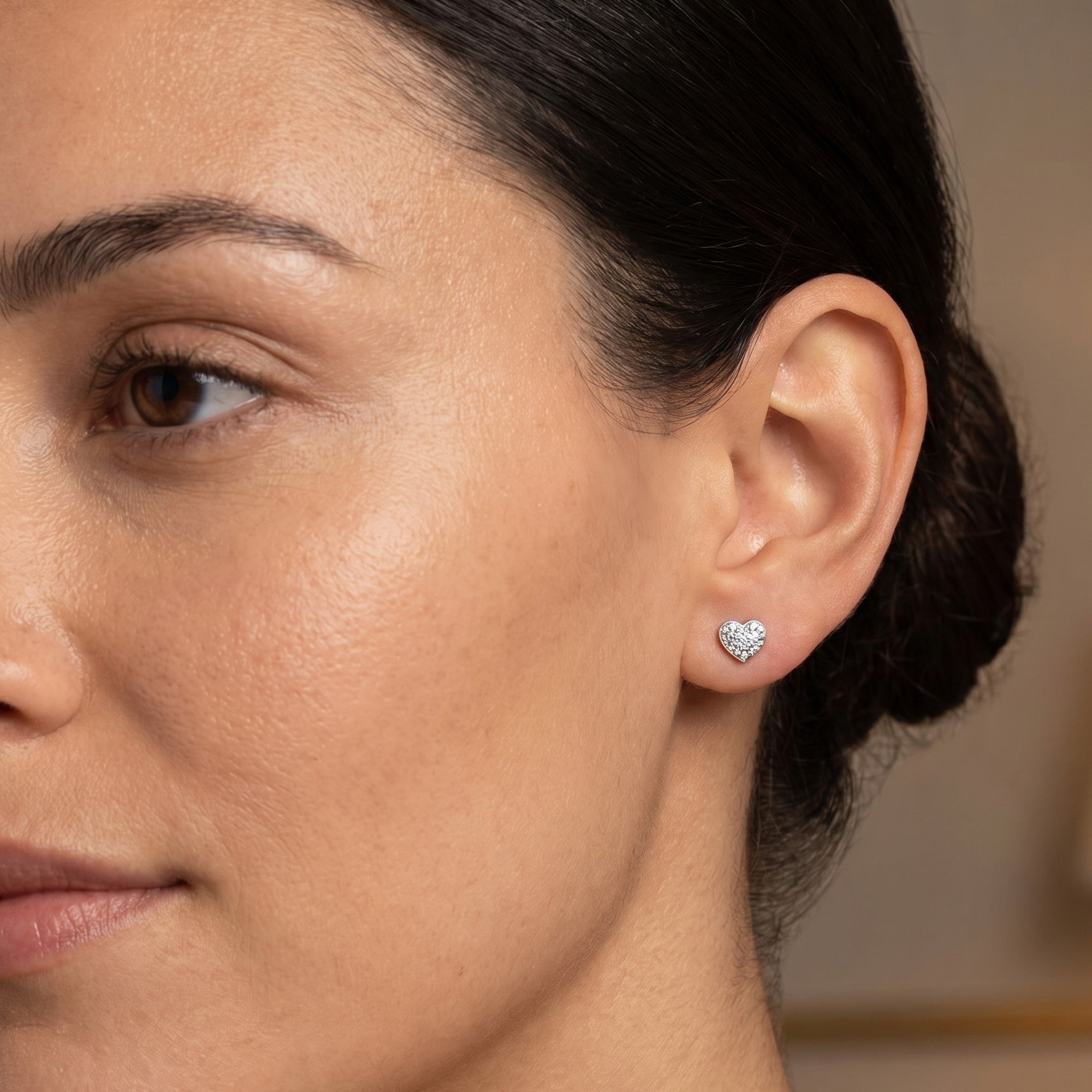 Woman wearing Engelsrufer mini heart pave CZ silver stud earrings.