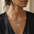 Woman wearing sterling silver yin yang om balance necklace.