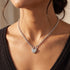 Woman wearing a pave heart padlock sterling silver belcher chain necklace.