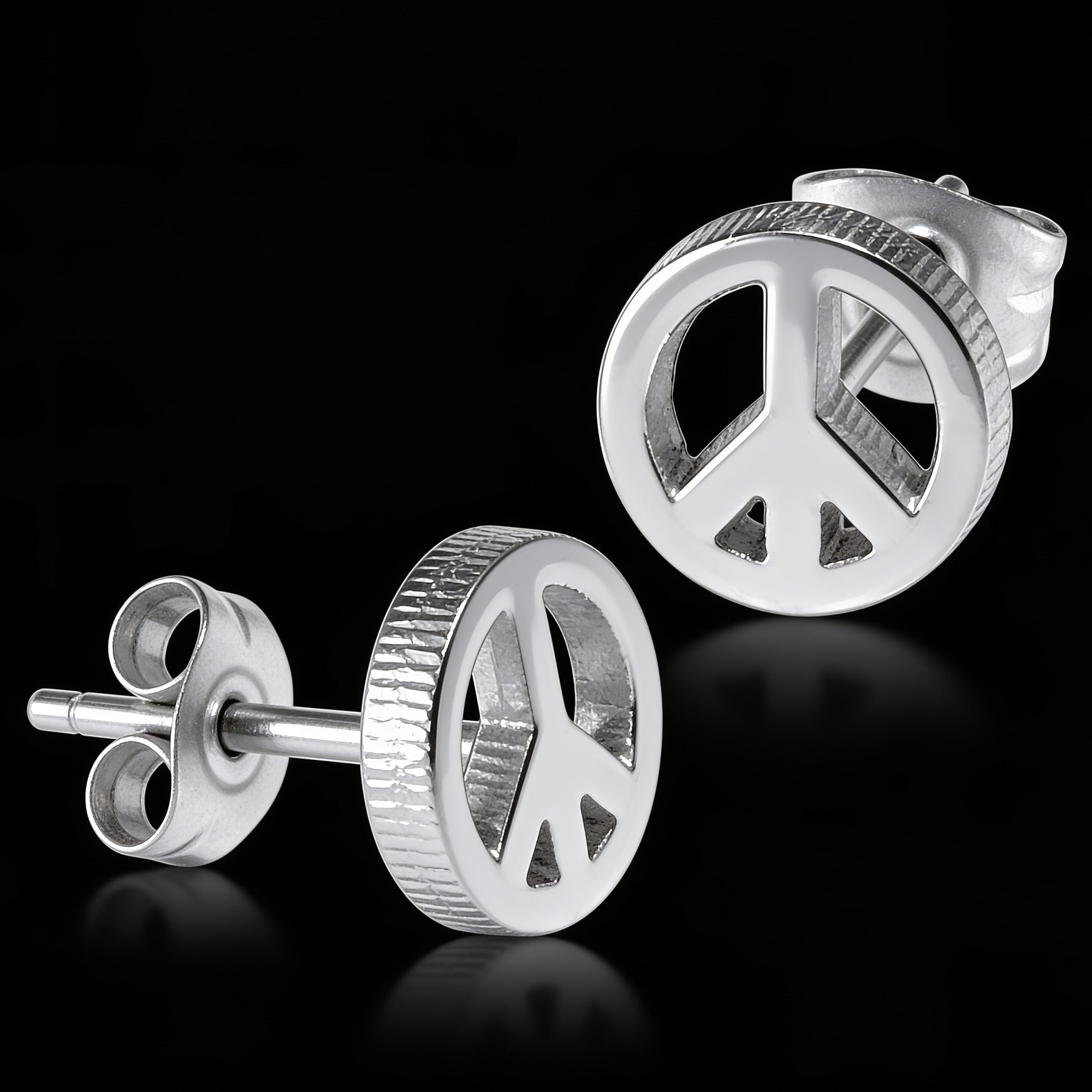 Peace symbol stainless steel stud earrings sitting on a black mirror surface.