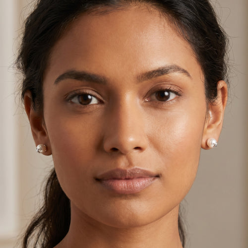 Woman wearing Engelsrufer pearl flower sterling silver stud earrings.