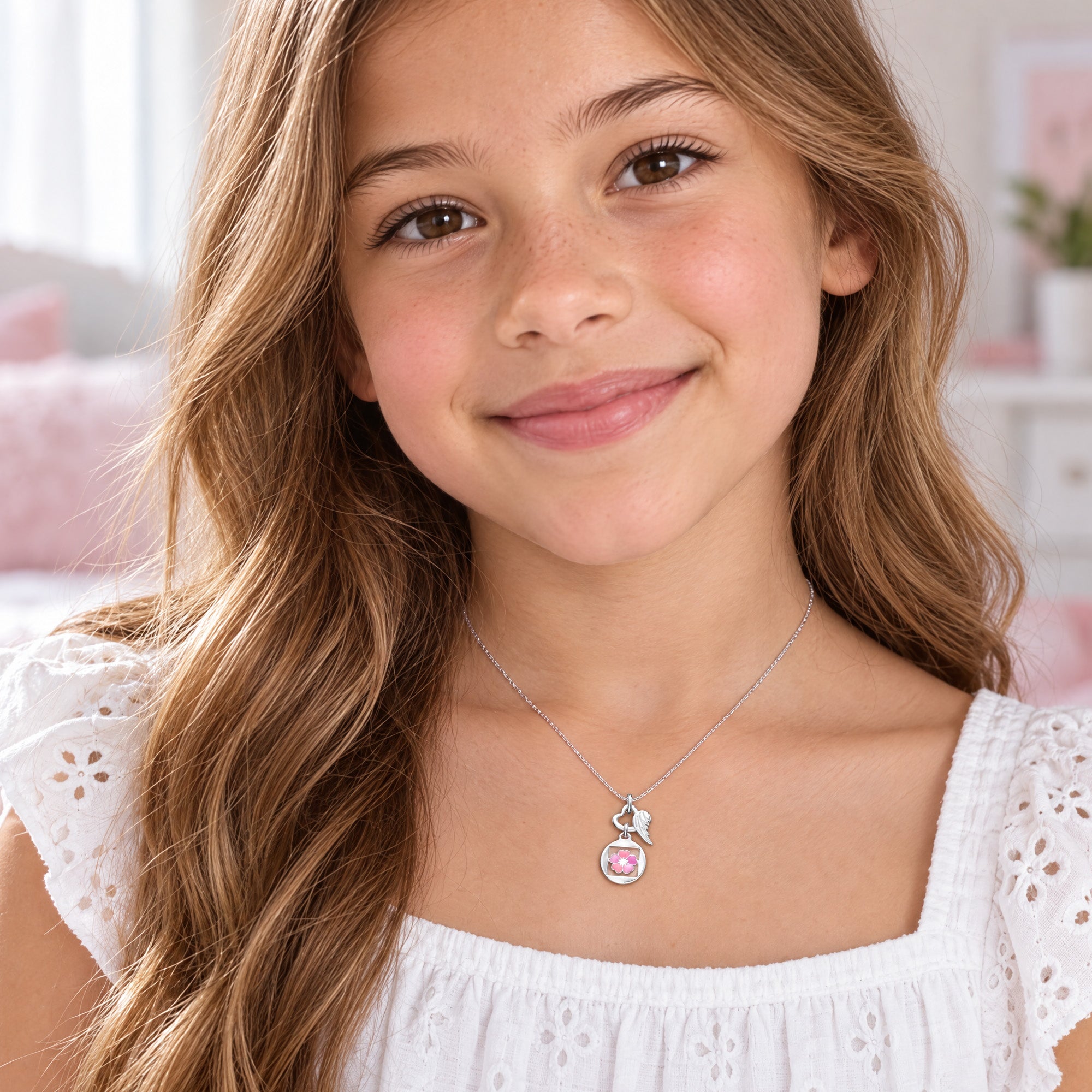 Young girl wearing Herzengel beautiful pink flower heart wing silver children's necklace.