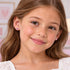 Young girl wearing Herzengel pink heart CZ silver children's stud earrings.