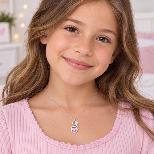 Young girl wearing Herzengel pink love heart wing silver children's necklace.