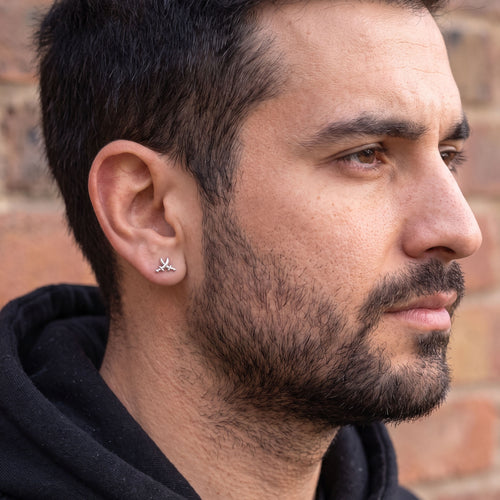 Side profile of man wearing pirate swords stainless steel stud earring.