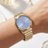 Woman wearing Police ladies Celebration powder blue dial gold watch.
