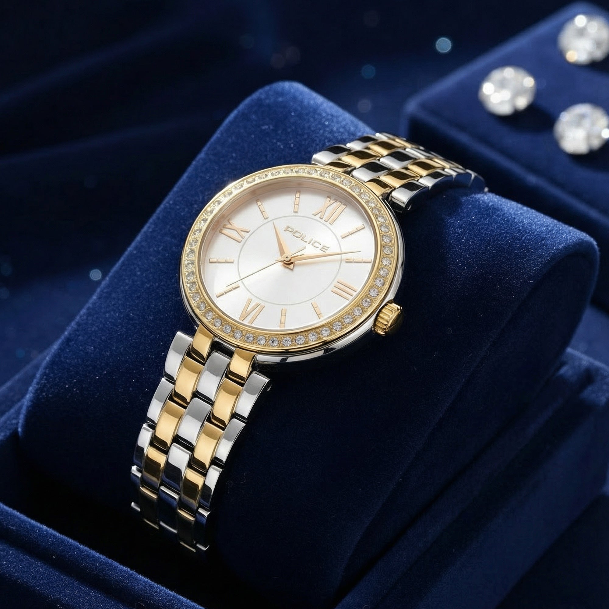 Police ladies Magnificence gold two-tone watch displayed on blue velvet cushion.
