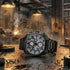 Police Norwood all black men's watch sitting on a factory work bench with sparks flying in the background.