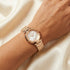 Close-up of a woman wearing Police ladies Attraction pearl dial rose gold watch on her wrist.