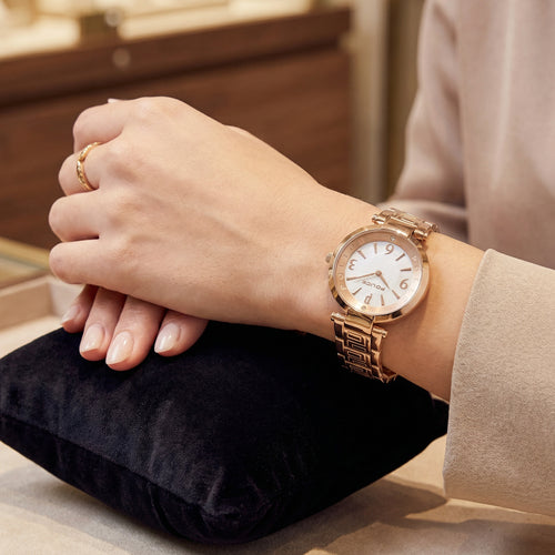 Woman wearing Police ladies Attraction pearl dial rose gold watch.