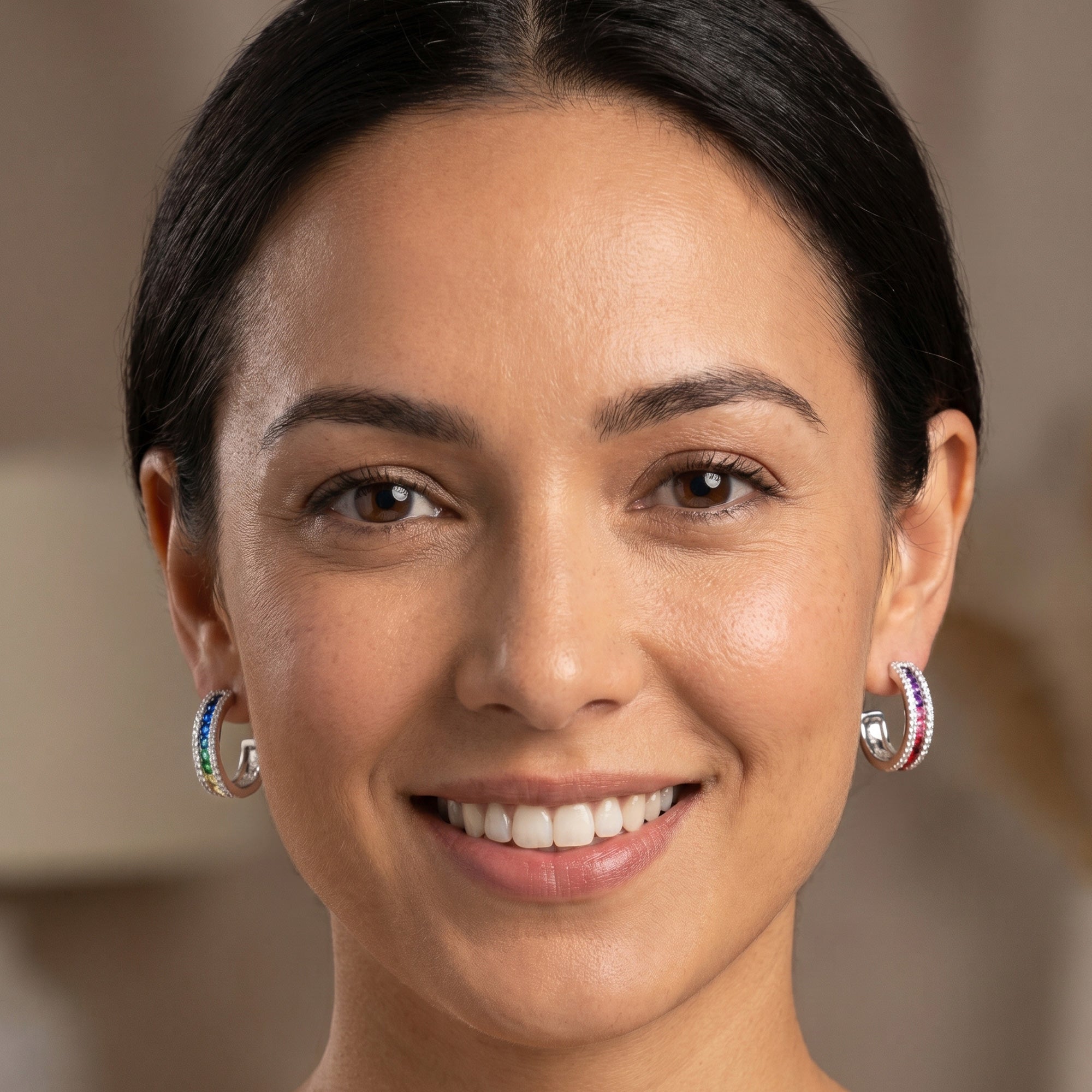 Woman wearing Ellani rainbow silver channel set hoop earrings.