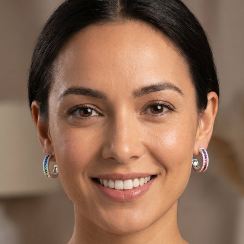 Woman wearing Ellani rainbow silver channel set hoop earrings.