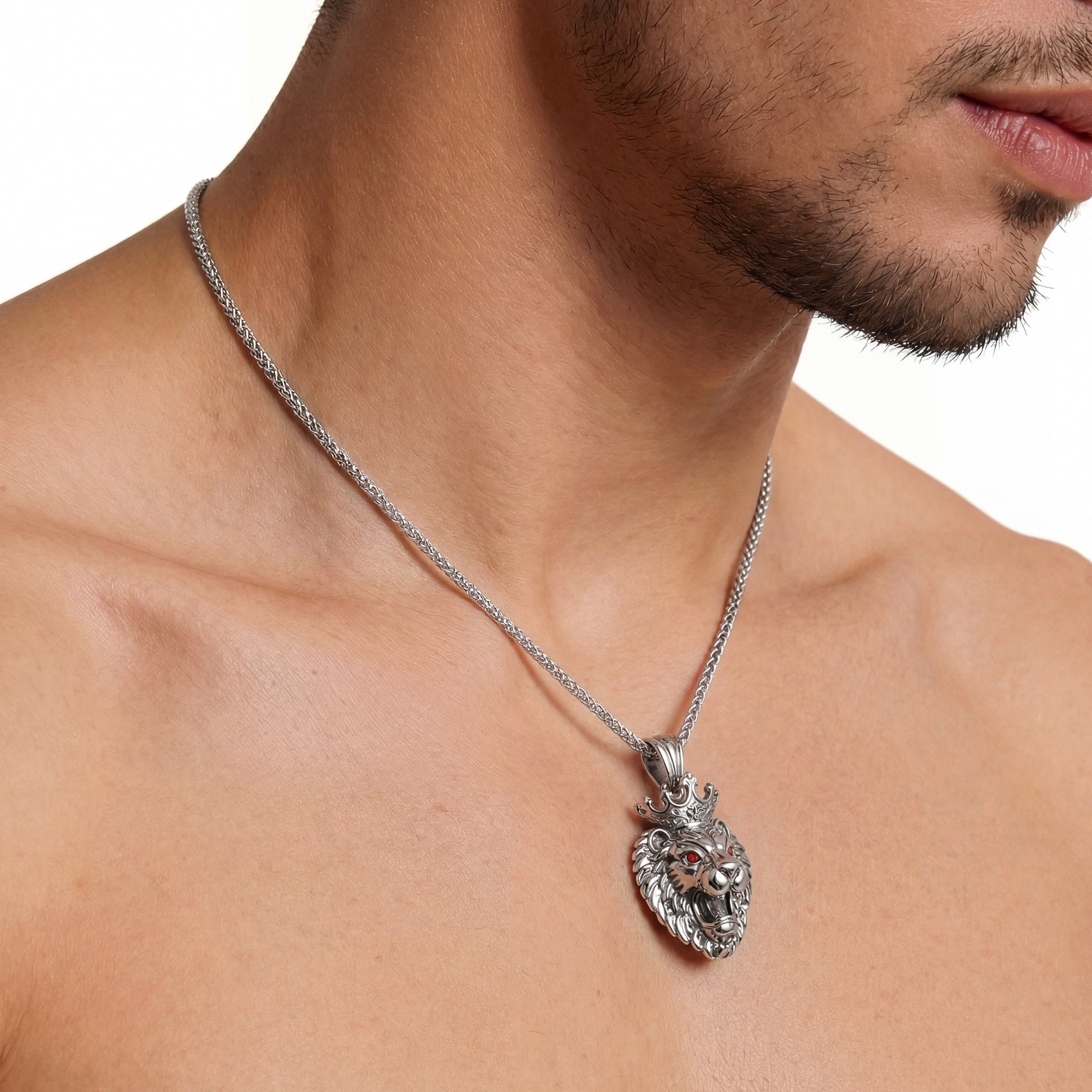 Close-up of man wearing stainless steel roaring lion head king crown necklace.