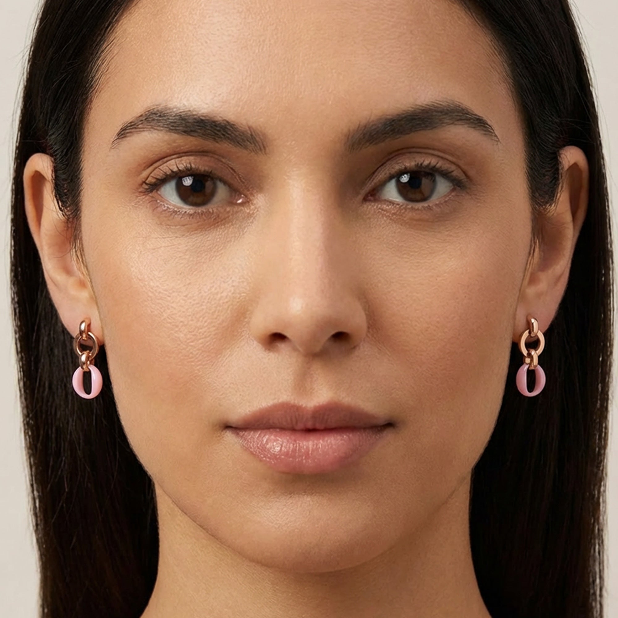 Woman wearing sterling silver rose gold pink ceramic circle link earrings.