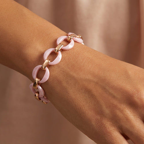 Woman wearing a sterling silver rose gold pink ceramic circle link bracelet on her wrist.