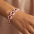 Woman wearing a sterling silver rose gold pink ceramic circle link bracelet on her wrist.
