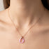 Close up of a woman wearing a sterling silver rose gold pink ceramic circle necklace.a